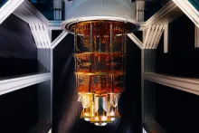 The gold chandelier-like interior of a quantum computer cryostat, showing its layered wiring and cooling stages.