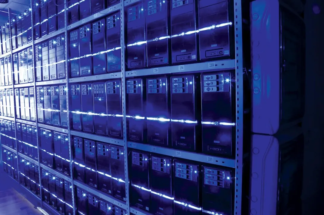 Rows of servers fill a data centre room, lit in blue, of the kind planned for large-scale AI training and inference workloads.